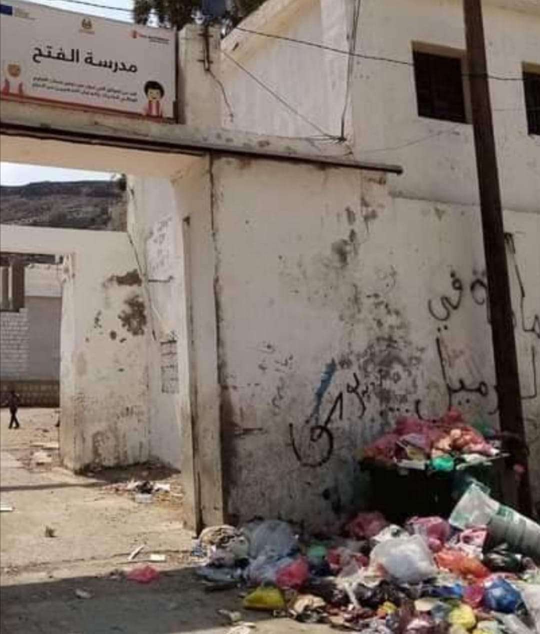 في مشهد غريب .. القمامة تُحاصر مدرسة في عدن (صورة)